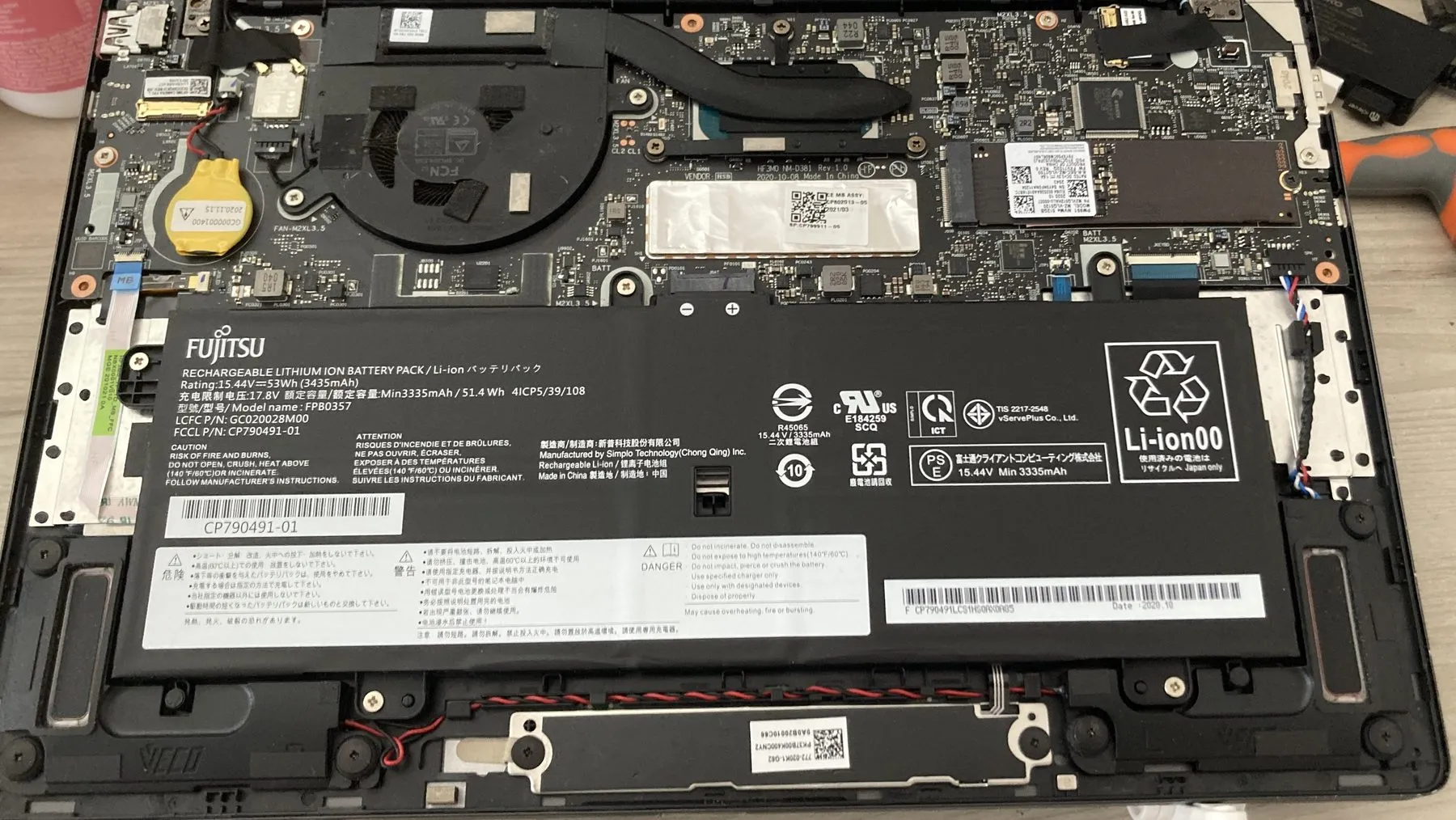 The inside of a laptop with the storage drive and cooling assembly visible