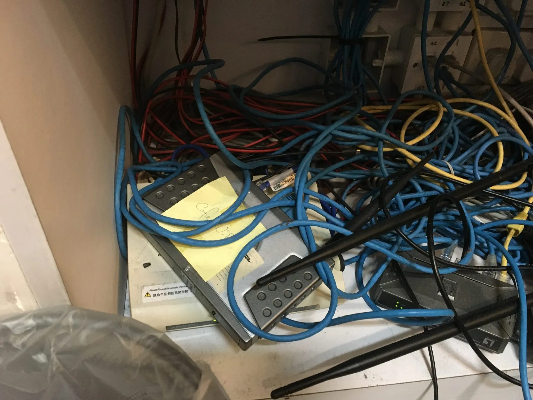A wall-mounted network cabinet with a switch and patch cabling